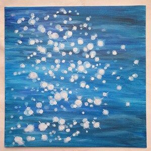 May include: An abstract painting on canvas featuring a deep blue background with white, circular, and star-like shapes. The artwork evokes a sense of depth and movement, resembling light reflecting on water.