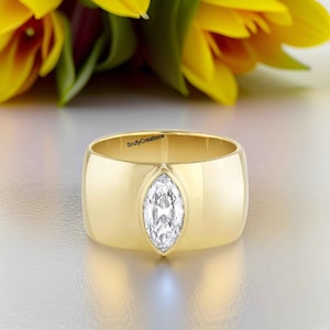 Einzigartig dieser mutige Ring hat 1 CT Marquise Cut Moissanite Diamant Lünette in einem klobigen Zigarrenband für ein modernes Gefühl, 14k Gelbgold