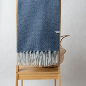 Cashmere and merino throw in blue, with fringes on short sides. Merino and cashmere throw blanket. Sofa plaid.