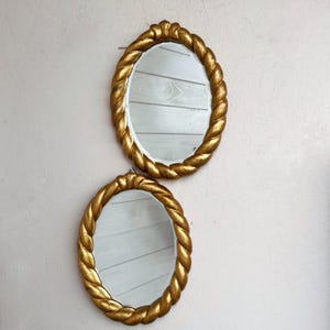 Pair of vintage Italian mirrors with worked and gilded frame and mirror with ground edge. Italian wall mirrors. Vintage props.