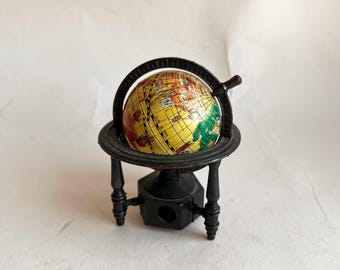 Miniatuur metalen wereldkaart, vintage puntenslijper. Vintage puntenslijper, gemaakt in Hong Kong. Metalen puntenslijper voor wereldkaart.