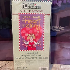 May include: A red and white house flag with the text "You Have My Heart On A String" and a cartoon girl holding a string of hearts. The flag is 25 inches by 38 inches.