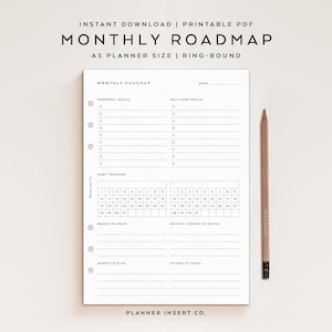 May include: A white ceramic mug with a black handle and the text "But First, Coffee" in a bold, black font. The mug is set against a blurred background. The mug appears to be approximately 10 cm tall.