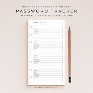 May include: A white password tracker insert with a pencil. The insert has sections for website, email, username, password, and notes. The text "PASSWORD TRACKER" is at the top. The pencil is brown with a black eraser.