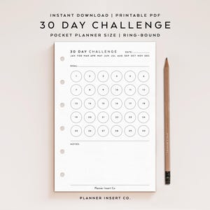 May include: A white paper planner insert for a ring-bound system featuring a 30 day challenge grid with numbered circles from 1 to 30. The page includes headers for date, goal, and notes, with months listed at the top and a wooden pencil beside it.