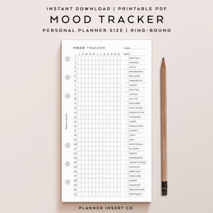 May include: A printable mood tracker planner insert with a grid for daily tracking and a key of emotions. The text "MOOD TRACKER" and "PERSONAL PLANNER SIZE" are at the top. A wooden pencil rests beside the planner.