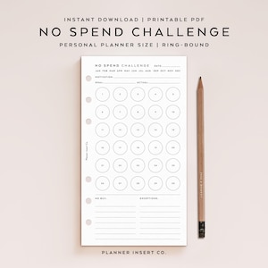 Puede incluir: Un inserto de planificador PDF imprimible en blanco con el texto "NO SPEND CHALLENGE" y una cuadrícula para el seguimiento de gastos. Un lápiz de madera descansa en el lado derecho de la página. El planificador es de anillas y de tamaño personal.
