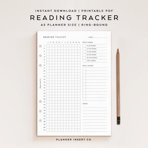 May include: A white A5 planner insert with a grid for tracking reading progress, labeled "Reading Tracker." The insert includes sections for the year, keys, and notes, with a pencil resting alongside. The text "Planner Insert Co." is at the bottom.