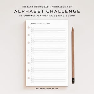Könnte beinhalten: Ein weißes Planer-Insert mit dem Text "ALPHABET CHALLENGE" und linierten Seiten. Ein Bleistift aus Holz mit einem schwarzen Radiergummi liegt neben dem Planer. Der Planer ist ringgebunden und mit "FC COMPACT PLANNER SIZE" beschriftet.
