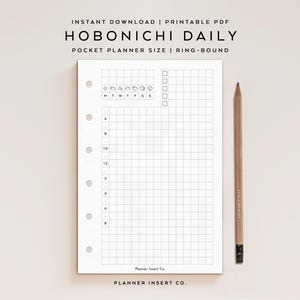 May include: A white Hobonichi Daily pocket planner insert with a grid layout, time slots, and weather icons. The text "HOBONICHI DAILY" and "POCKET PLANNER SIZE" are visible. A wooden pencil rests on the right side of the planner.