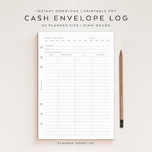May include: A white A5 planner insert with a cash envelope log layout. The page includes sections for tracking cash flow, with headings like "Cash Tracker," "Category," and "Balance." A wooden pencil rests beside the planner. Text at the top reads "Cash Envelope Log."