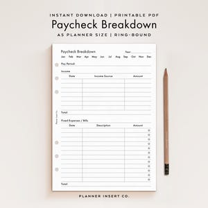 May include: A white A5 planner insert with the text "Paycheck Breakdown" and sections for income and expenses. A wooden pencil rests on the right side. The planner is ring-bound and includes the text "Instant Download | Printable PDF".
