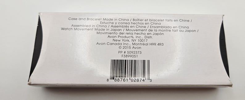 May include: A white product box with black accents, featuring printed text in multiple languages. The text includes details about the case, bracelet, and watch movement origin, along with the manufacturer's information and a barcode.