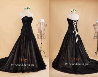 May include: A black strapless wedding dress with a fitted bodice and a full tulle skirt. The dress features a lace overlay and a corset back with white satin ribbon ties. The dress is shown on a white mannequin. The text "Etsy Rancool design" is visible on the bottom of the image.