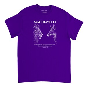 May include: A purple t-shirt with a white graphic of a lion and a fox facing each other. The text "MACHIAVELLI" is above the images, with a quote below. The shirt is a crew neck style.