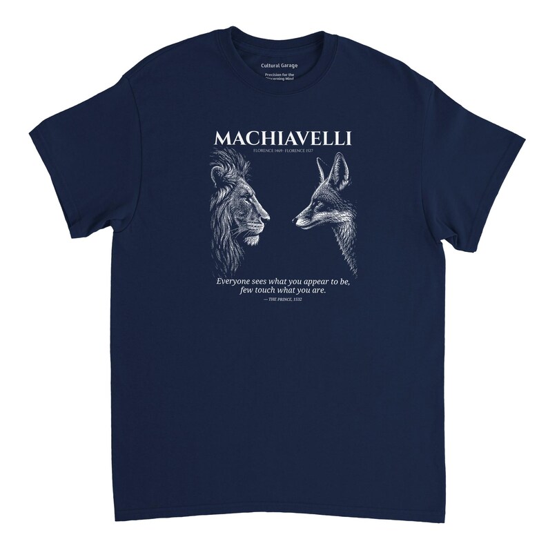 May include: Navy blue t-shirt featuring a white graphic of a lion and a fox facing each other, with the name "MACHIAVELLI" above them. The shirt also includes a quote from "The Prince" by Machiavelli.