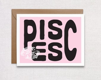 May include: A pink card with the word "PISCES" in black block letters. Two white fish with stars are in the bottom left corner.
