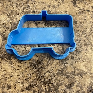 Pu&ograve; includere: Un tagliapasta in plastica blu a forma di furgone.