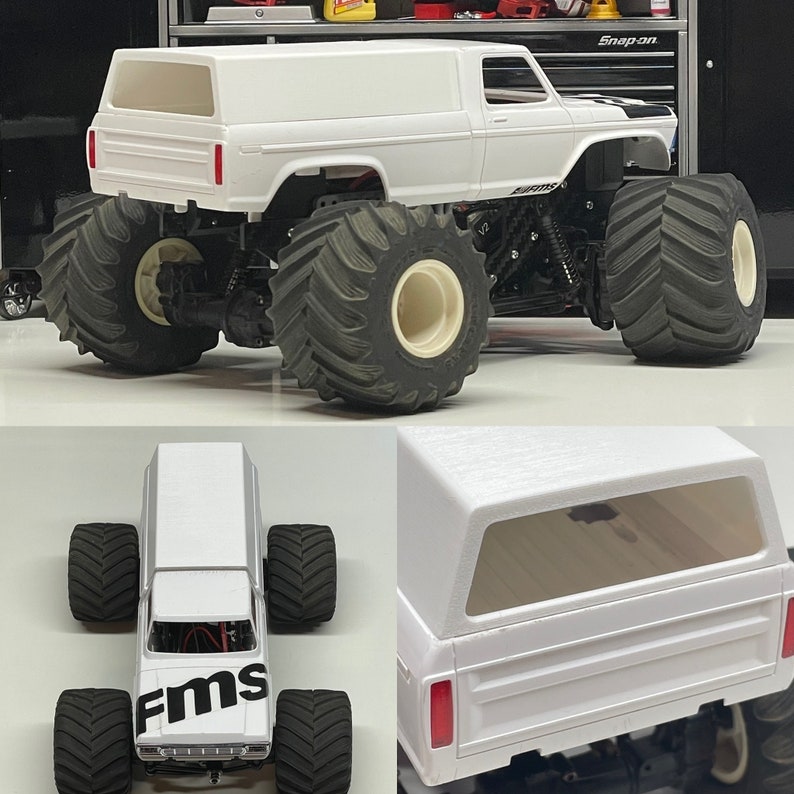 Peut inclure: Camion monster blanc avec une cabine blanche et de gros pneus noirs. Le camion a un logo "FMS" noir sur le c&ocirc;t&eacute;.