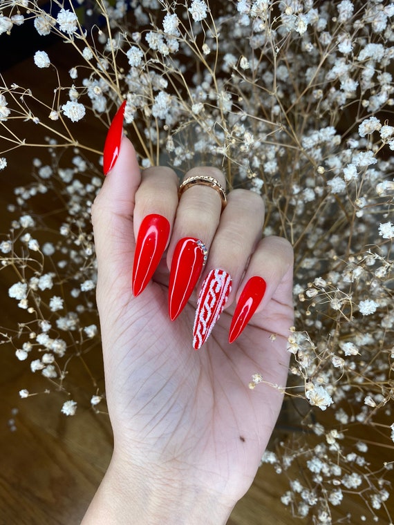 Female hands with manicure in sweater. Red matt nail design Stock Photo -  Alamy