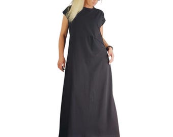 Könnte beinhalten: Ein bodenlanges schwarzes Maxikleid mit kurzen Ärmeln, einem Rundhalsausschnitt und einer geraden, locker sitzenden Silhouette. Das Kleidungsstück weist eine horizontale Naht im Brustbereich auf und wird mit schwarzen Sandalen und einer Sonnenbrille kombiniert.