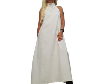 May include: A floor-length, sleeveless white dress featuring a high mock neck collar. The garment has a loose, flowing silhouette that extends to the ankles, crafted from a solid white fabric with a subtle texture, paired with black wedge sandals.
