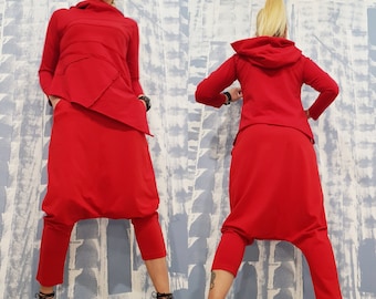 May include: A red two-piece outfit with a long-sleeved top and loose-fitting trousers. The top has a high neckline and a hood. The trousers have a wide leg and a gathered waist.