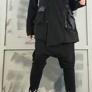 Op de afbeelding: Zwarte hoodie met rits en grote zakken. De jas heeft een losse pasvorm en is gemaakt van een zachte, comfortabele stof.