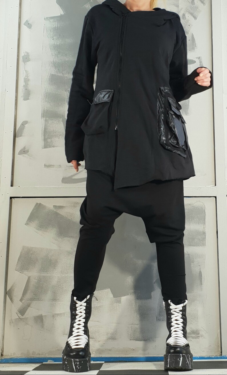 Op de afbeelding: Zwarte hoodie met rits en grote zakken. De jas heeft een losse pasvorm en is gemaakt van een zachte, comfortabele stof.