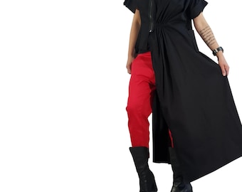 May include: A black short-sleeved tunic featuring a front zipper closure and gathered waist detail, paired with bright red trousers and black open-toe heeled boots. The tunic has an asymmetrical hemline that extends longer on one side.