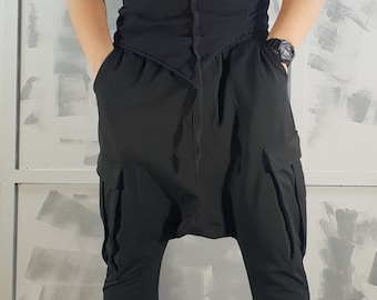 May include: A black t-shirt with a long, thin strap detail on the front, paired with black cargo pants and black high-top sneakers.