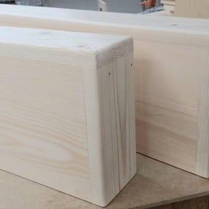 May include: Two unfinished wooden boxes with rounded edges. The boxes are made of light-colored wood and have a natural grain pattern.