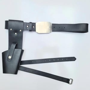 May include: Black leather belt with a metal buckle and a holster attached. The holster has a flap that can be secured with a snap.