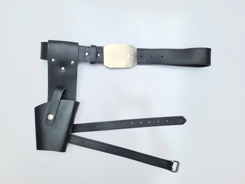 May include: Black leather belt with a metal buckle and a holster attached. The holster has a flap that can be secured with a snap.