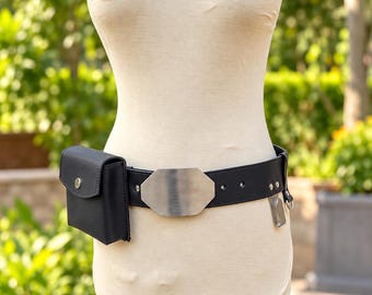 May include: A black utility belt featuring a smooth, octagonal silver-toned metal buckle at the center. The belt includes a rectangular black pouch with a snap closure on the left side and a small silver-toned metal clip attached to the right side.