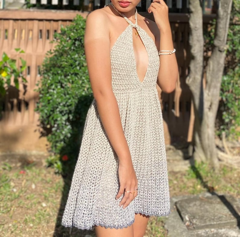 May include: A white crochet halter dress with a plunging neckline and a blue ombre effect at the hem.
