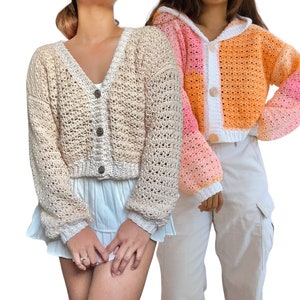 Puede incluir: Dos cárdigans de crochet, uno en color beige y el otro en un patrón de degradado multicolor de rosa, naranja y blanco. Ambos cárdigans tienen cierre de botón y son cortos.
