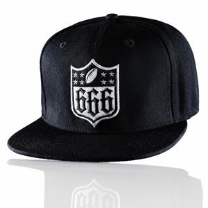 May include: Black flat-brim baseball cap with a white embroidered emblem. The emblem features a football, stars, and the number "666" in a gothic font. The cap has a structured crown and a flat brim.