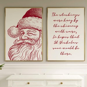 Puede incluir: Dos impresiones enmarcadas con una ilustración roja y blanca de Santa Claus y una cita de texto rojo sobre colgar medias de Navidad en la chimenea con cuidado. La cita dice: "The stockings were hung by the chimney with care, In hopes that St Nicholas soon would be there."