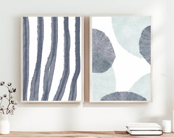 May include: Two framed abstract art prints with a white background. The print on the left features vertical blue and gray stripes. The print on the right features blue and gray circles.