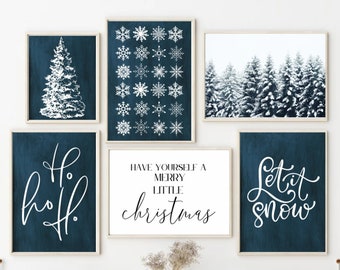 May include: A set of five blue and white Christmas-themed prints with white text. The prints feature a snowy forest, snowflakes, a Christmas tree, and the phrases "Ho Ho Ho", "Have Yourself a Merry Little Christmas", and "Let it Snow".