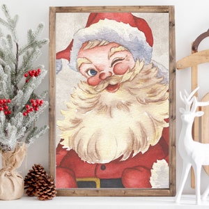 May include: A vintage-style illustration of Santa Claus with a white beard and red hat, winking and smiling. The illustration is framed in a wooden frame.