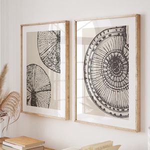 May include: A wooden console table with a light wood finish. The table has two shelves and is decorated with a vase of dried flowers, books, and a framed print of a black and white design.