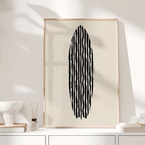 Puede incluir: Una impresi&oacute;n abstracta en blanco y negro de una forma ovalada ondulada en un marco beige claro. La impresi&oacute;n est&aacute; colgada en una pared blanca sobre un armario blanco.