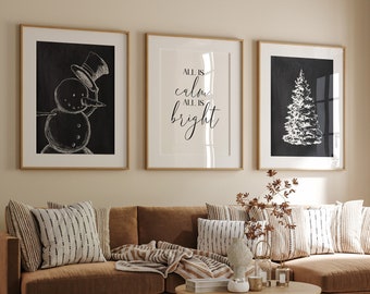 May include: A brown sectional sofa with a white and black striped throw blanket and pillows. Three framed black and white illustrations hang on the wall above the sofa. The illustrations depict a snowman, a Christmas tree, and the text "All is calm, all is bright".