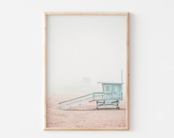 Könnte beinhalten: Ein hellblauer Rettungsschwimmerstand an einem Sandstrand mit einem Holzsteg, der zu ihm führt. Der Stand hat ein Schild mit der Aufschrift "Lifeguard Stand".