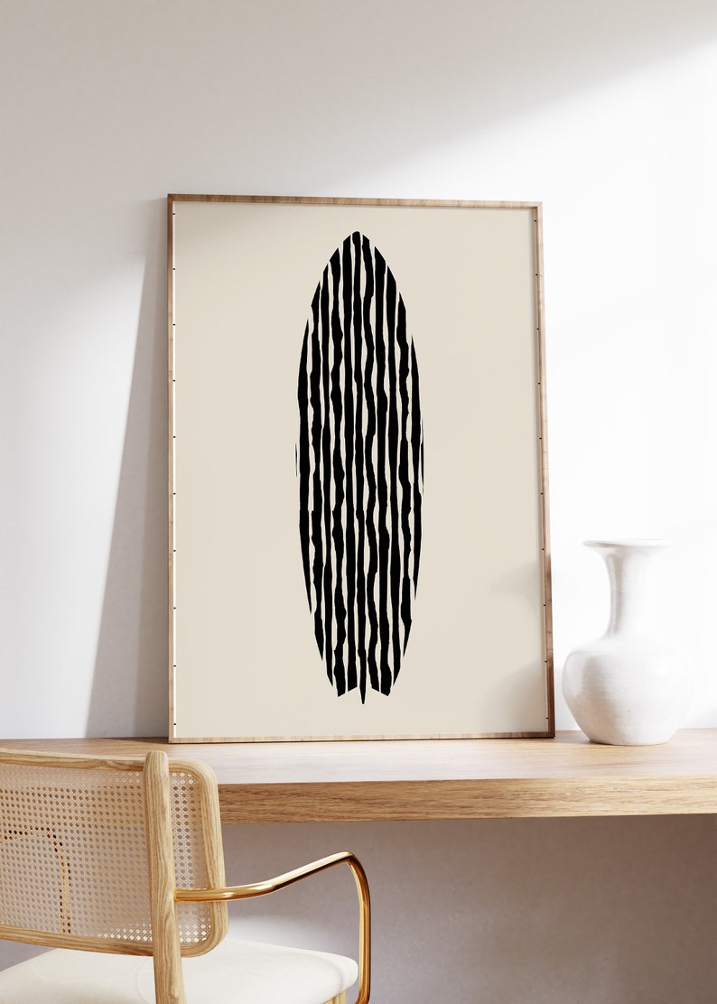 Puede incluir: Impresi&oacute;n de arte abstracto en blanco y negro de una tabla de surf con un patr&oacute;n ondulado. La impresi&oacute;n est&aacute; enmarcada en un marco de madera claro y est&aacute; colgada en una pared blanca.