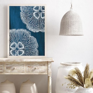Puede incluir: Una impresi&oacute;n enmarcada con un fondo azul y dos ilustraciones estilizadas blancas de medusas.