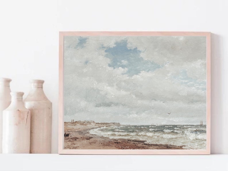 Puede incluir: Una pintura enmarcada que representa un paisaje mar&iacute;timo con un cielo nublado, una playa de arena y un oc&eacute;ano agitado con olas. La pintura est&aacute; en un marco de madera claro.