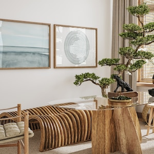 May include: A wooden table with a glass top and a unique curved wooden bench. The table is decorated with a small bonsai tree and a black sculpture. The room is decorated in a minimalist style with two framed prints on the wall.